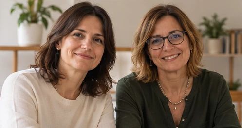 Una mediatrice sorride mentre dialoga con una coppia seduta di fronte a lei
